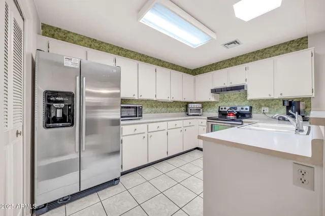 a kitchen with a refrigerator a sink and cabinets