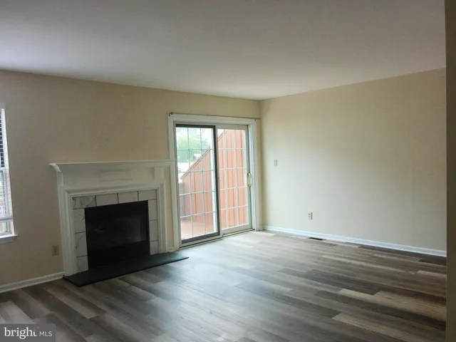 an empty room with wooden floor and fireplace