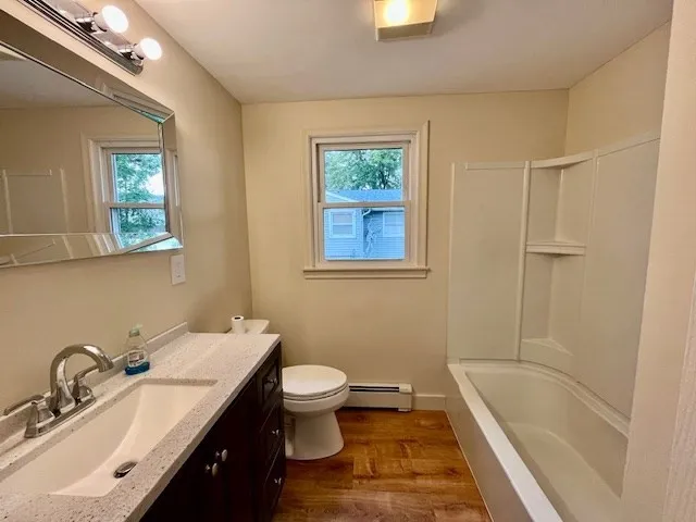 a bathroom with a granite countertop sink a toilet and shower