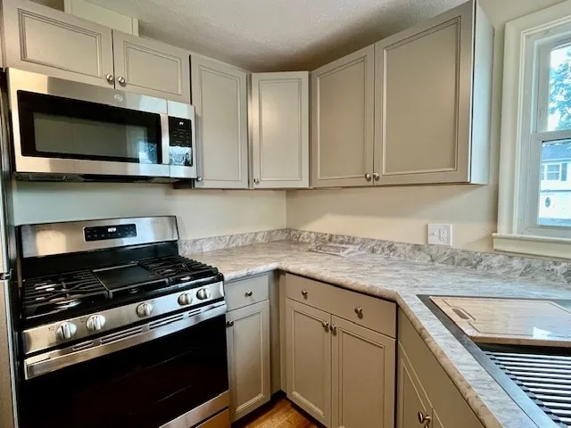 a kitchen with stainless steel appliances granite countertop a sink stove and microwave