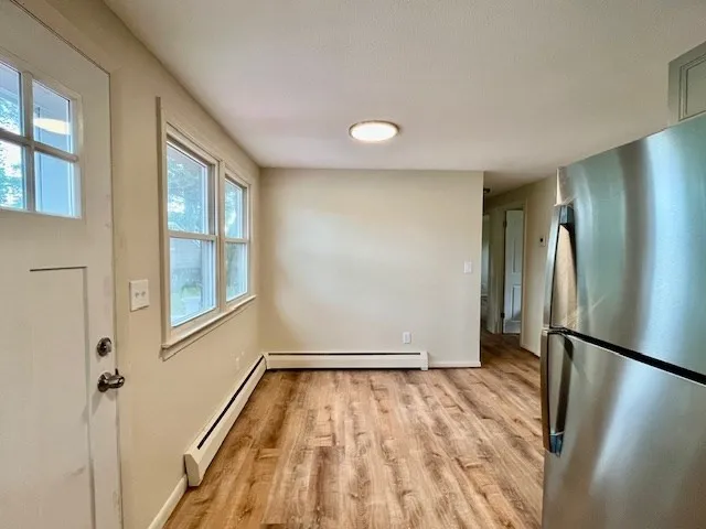 a view of empty room with wooden floor and window