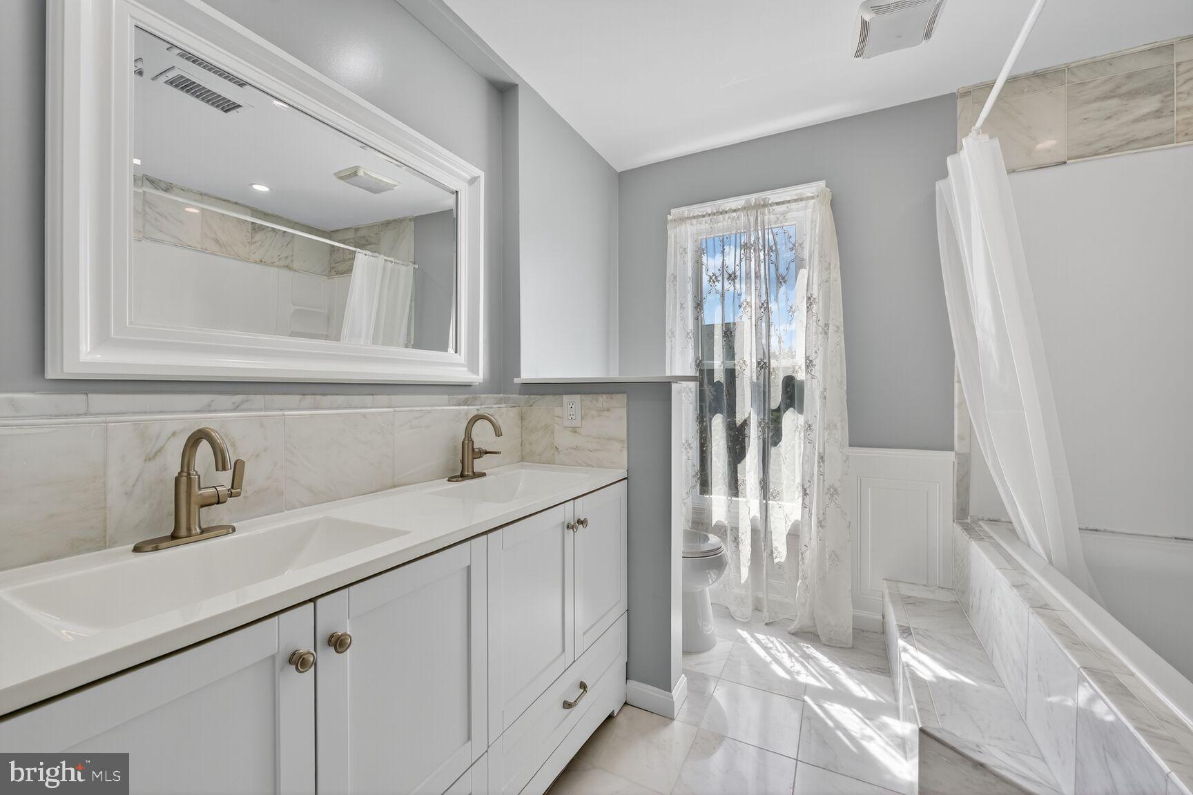 20970 Promontory Square Sterling, VA 20165 - Photo 21 of 44 a bathroom with a double vanity sink a mirror and a shower