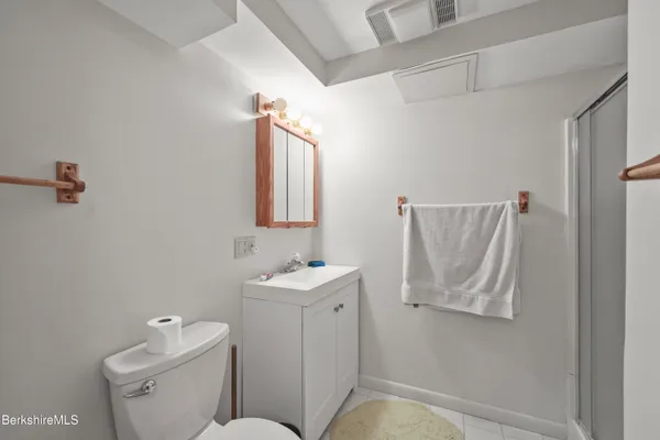 a bathroom with a sink and mirror with toilet