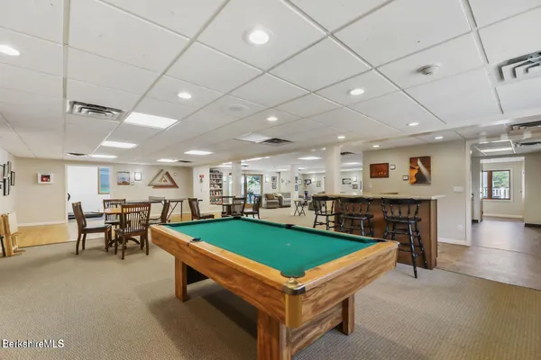 a room with lots of furniture and view of kitchen