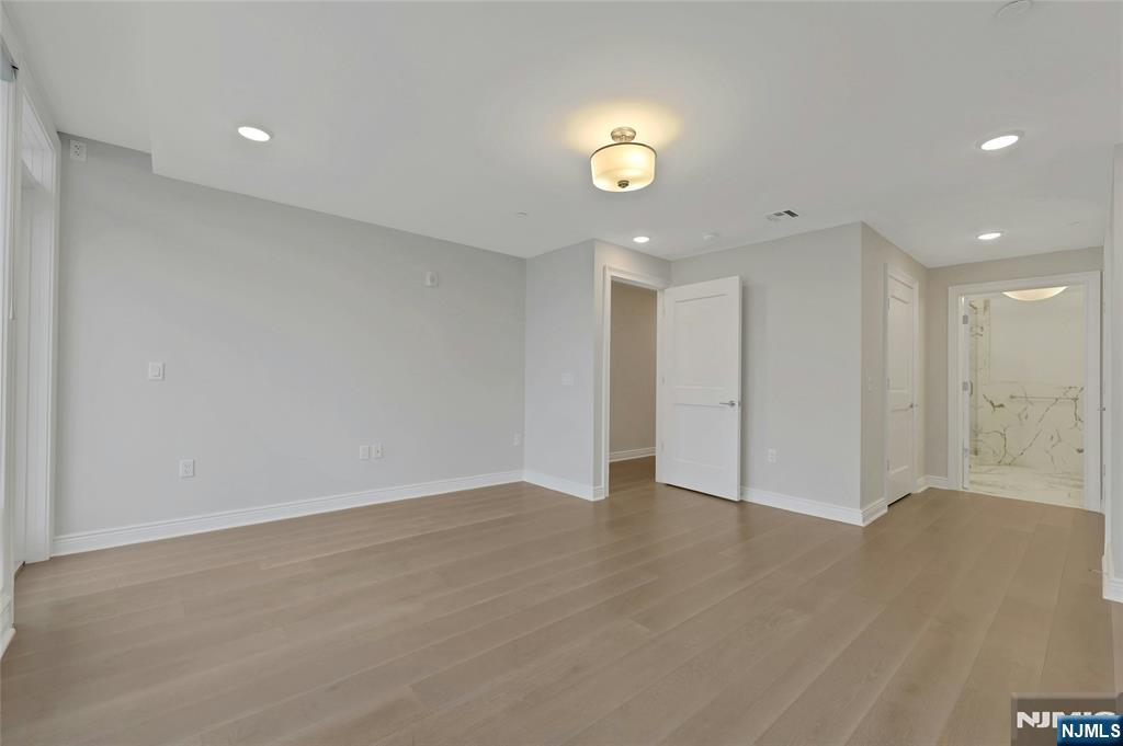 3 Somerset Lane, Unit 109 Edgewater, NJ 07020 - Photo 19 of 50 an empty room with wooden floor and windows