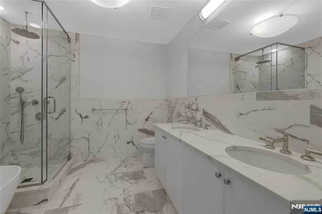 3 Somerset Lane, Unit 109 Edgewater, NJ 07020 - Photo 21 of 50 a bathroom with a sink toilet and shower