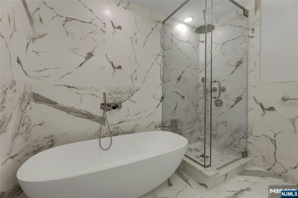 3 Somerset Lane, Unit 109 Edgewater, NJ 07020 - Photo 22 of 50 a bathroom with a bathtub and shower