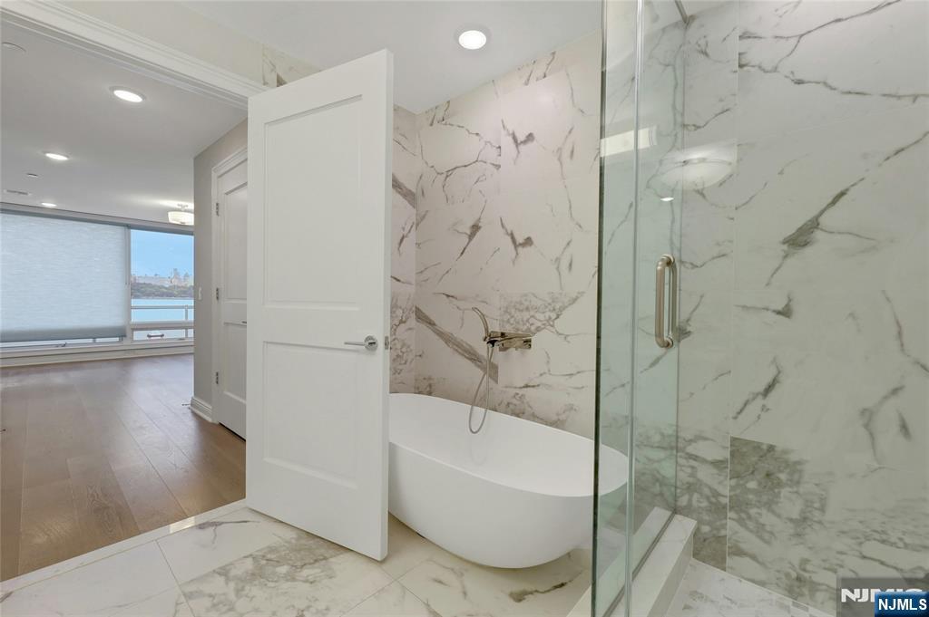 3 Somerset Lane, Unit 109 Edgewater, NJ 07020 - Photo 24 of 50 a bathroom with a bathtub and a shower