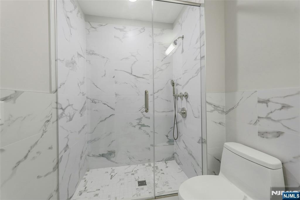 3 Somerset Lane, Unit 109 Edgewater, NJ 07020 - Photo 30 of 50 a white toilet and shower in a bathroom