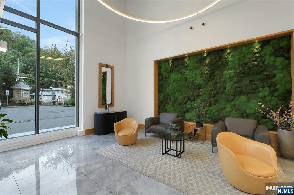 3 Somerset Lane, Unit 109 Edgewater, NJ 07020 - Photo 41 of 50 a living room with furniture and a floor to ceiling window