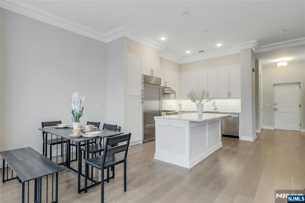 3 Somerset Lane, Unit 109 Edgewater, NJ 07020 - Photo 9 of 50 a kitchen with kitchen island a table and chairs in it