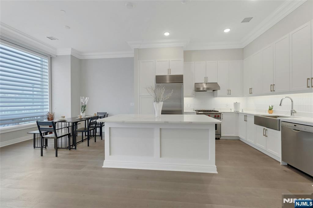 3 Somerset Lane, Unit 109 Edgewater, NJ 07020 - Photo 10 of 50 a kitchen with kitchen island a sink table and chairs
