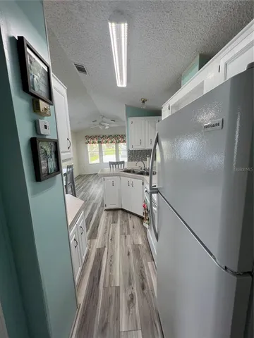 a kitchen with granite countertop a refrigerator and a sink