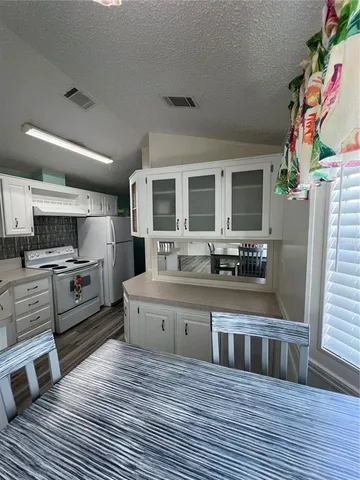 a large kitchen with stainless steel appliances granite countertop a stove and a sink