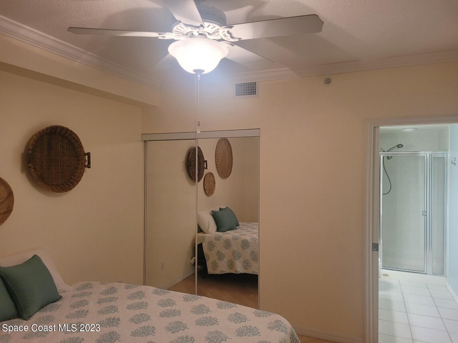 100 Riverside Drive, Unit 403 Cocoa, FL 32922 - Photo 17 of 30 a bedroom with a bed and a chandelier