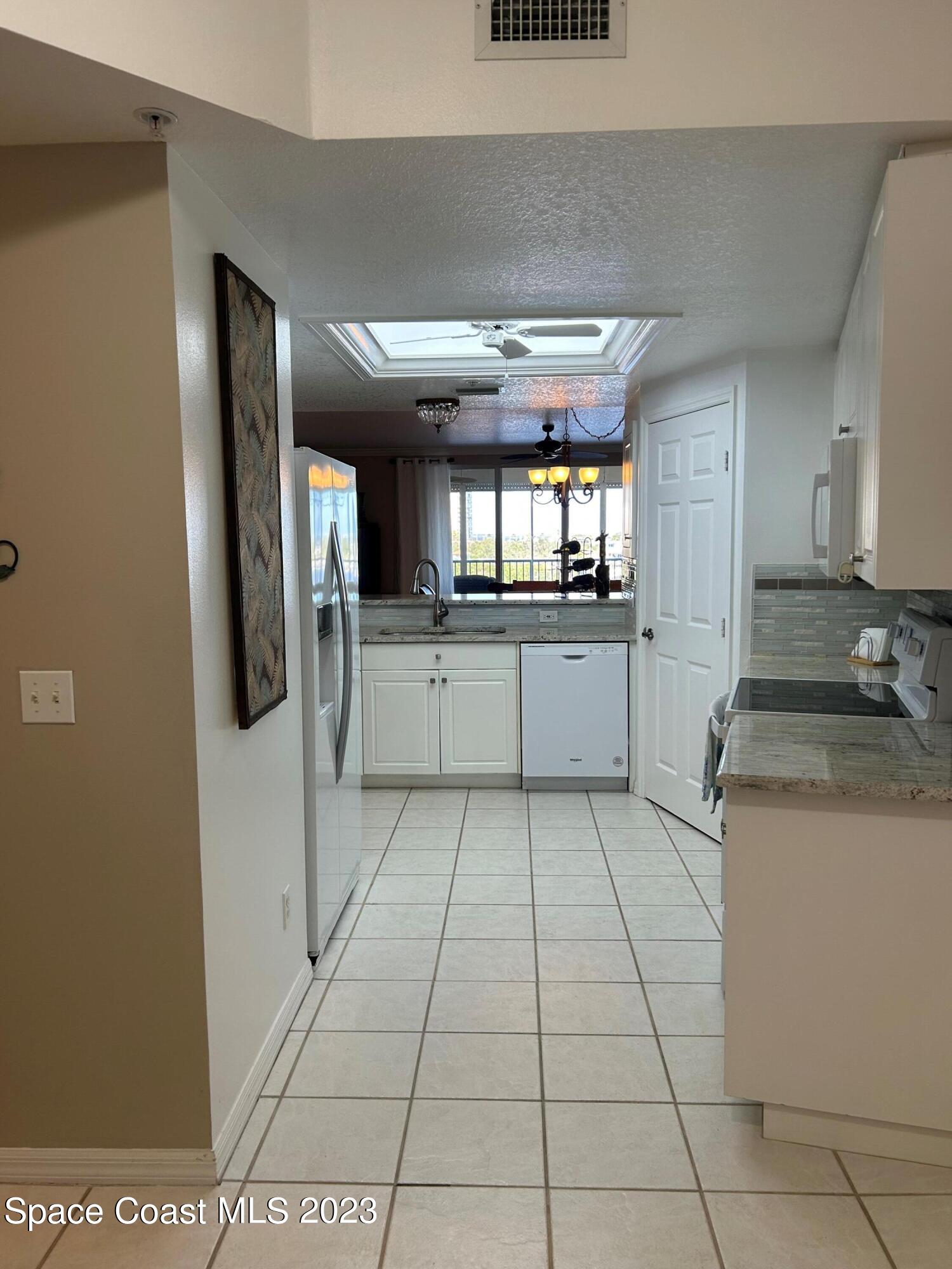100 Riverside Drive, Unit 403 Cocoa, FL 32922 - Photo 8 of 30 a kitchen with stainless steel appliances granite countertop a refrigerator and a sink