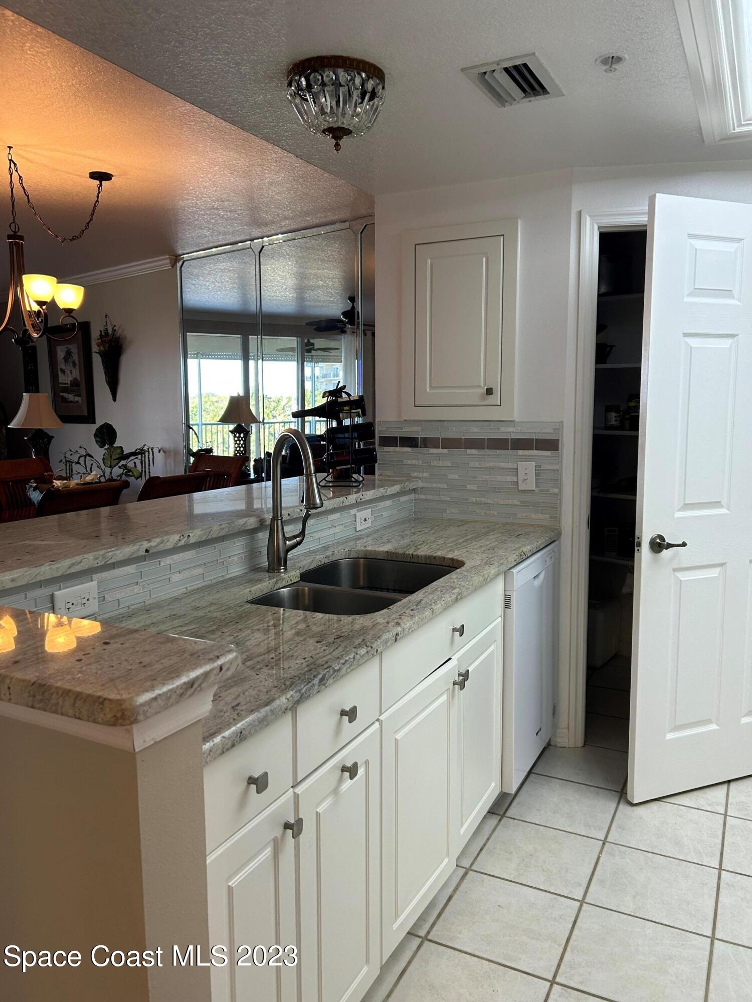 100 Riverside Drive, Unit 403 Cocoa, FL 32922 - Photo 9 of 30 a kitchen with stainless steel appliances granite countertop a sink stove and cabinets