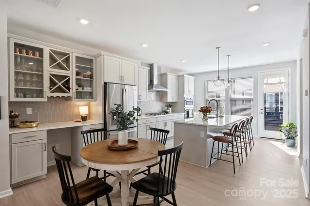 a kitchen with a dining table chairs and refrigerator