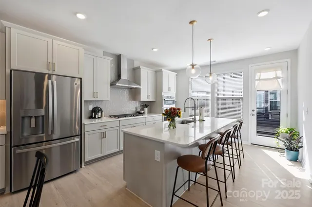 a kitchen with refrigerator a sink and chairs