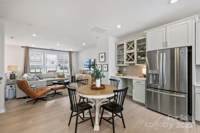a kitchen with a refrigerator a dining table and chairs