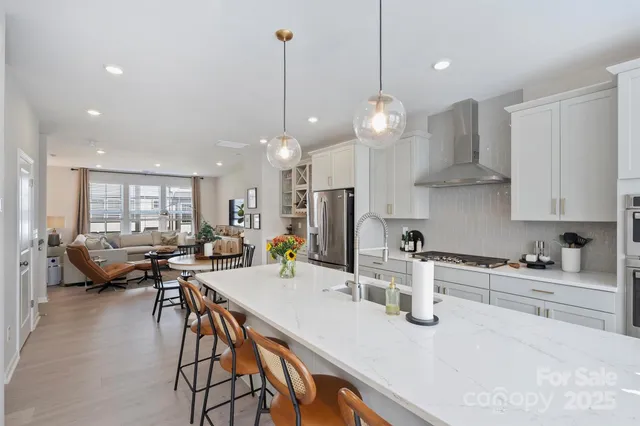 a kitchen with stainless steel appliances granite countertop a stove a sink a kitchen island with a dining table and chairs