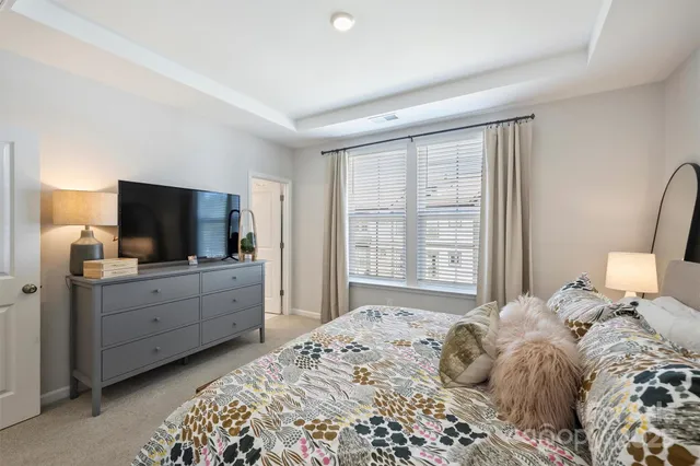 a bedroom with a large bed and a flat tv screen on dresser