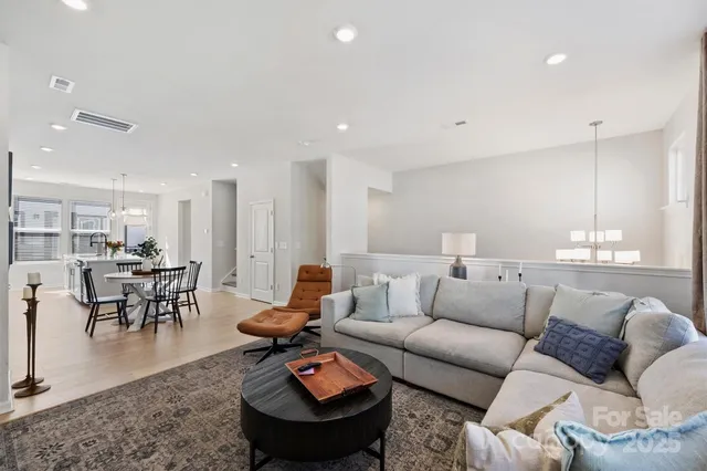 a living room with furniture and a dining table with kitchen view