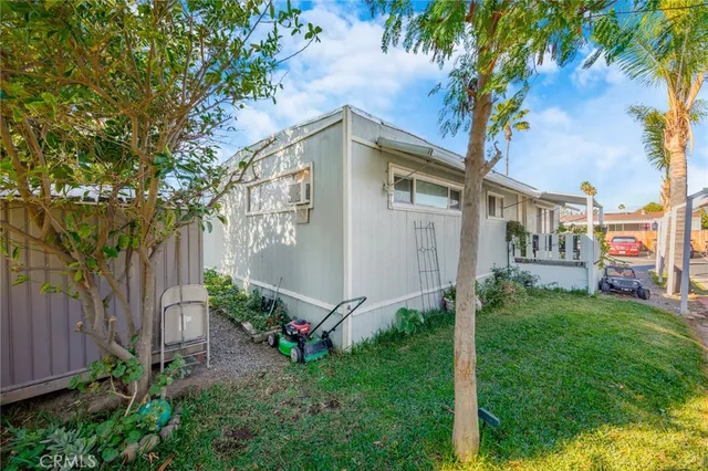 a view of a white house with a big yard and large trees