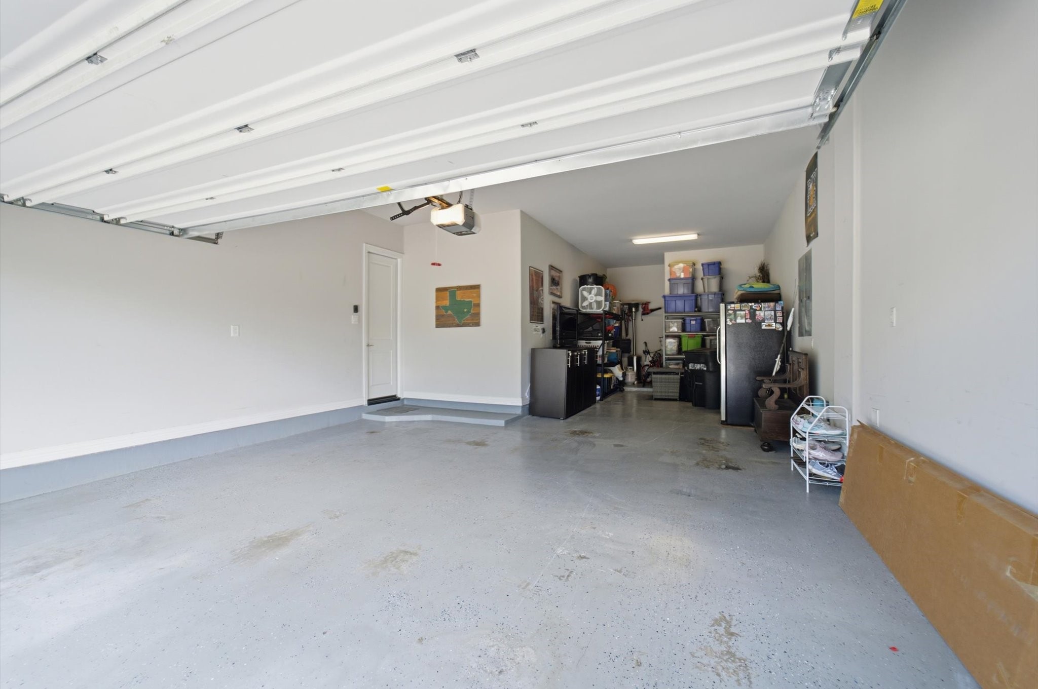 23722 Thortons Park Lane Spring, TX 77389 - Photo 18 of 48 This spacious garage features a clean, painted floor and ample room for storage with shelving and cabinets. It's well-lit and includes a door leading into the house, offering convenience and functionality.