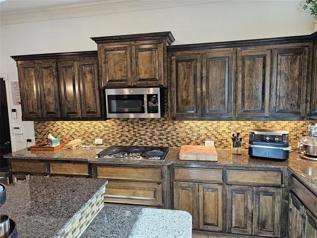 a kitchen with granite countertop a sink stove and cabinets