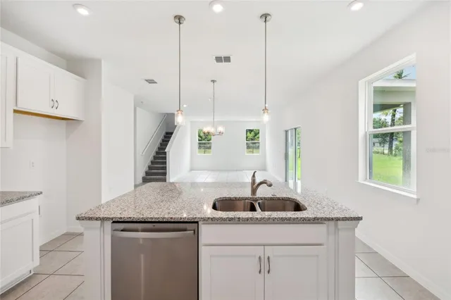 a kitchen that has a sink a window and stainless steel appliances