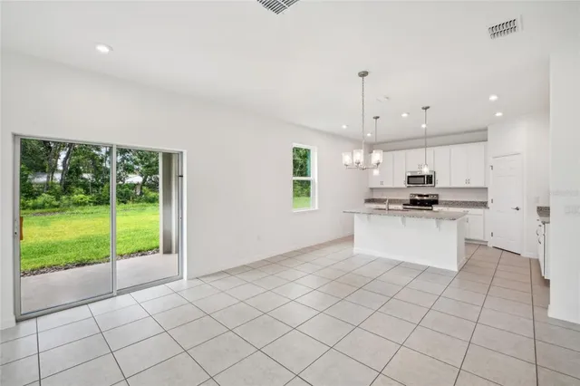 a kitchen with white cabinets and appliances