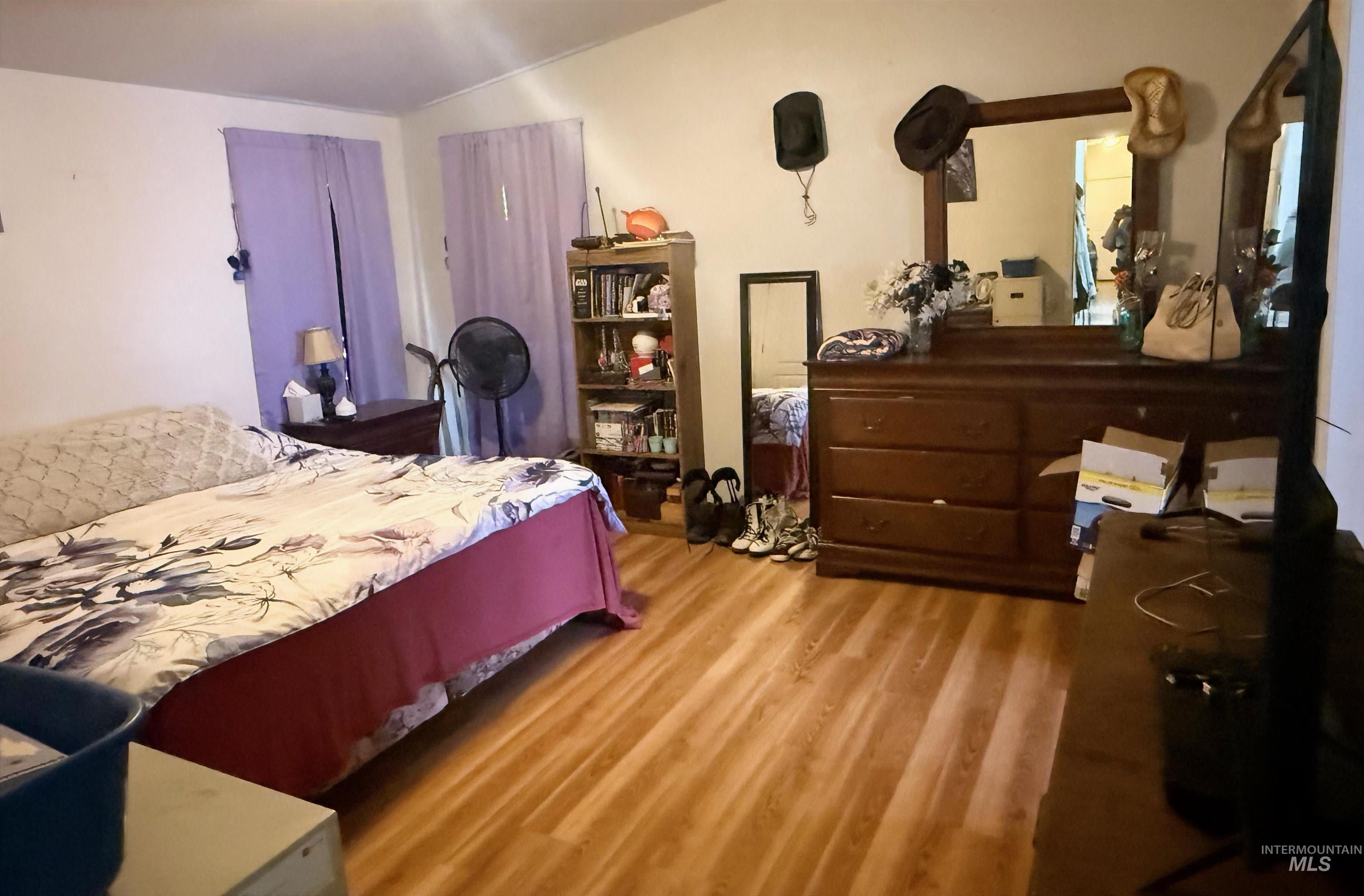 100 Ellsworth Street Vale, OR 97918 - Photo 11 of 25 Interior room featuring wood-finish flooring, white walls, and a window with light-filtering curtains