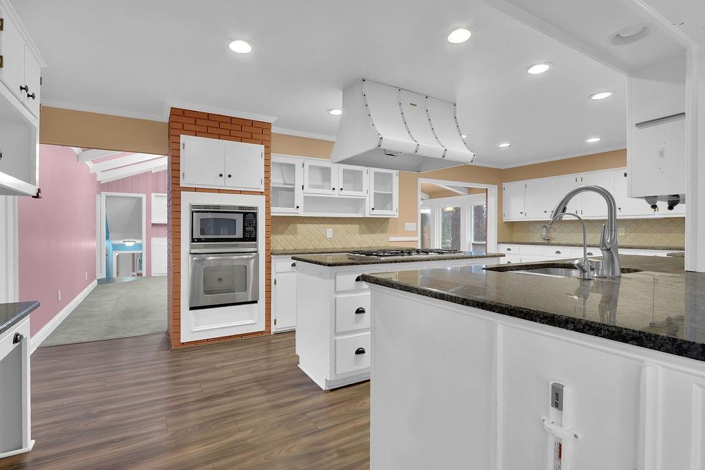 326 Fayette Drive Winder, GA 30680 - Photo 11 of 57 a kitchen with stainless steel appliances granite countertop a sink a stove and a wooden floors
