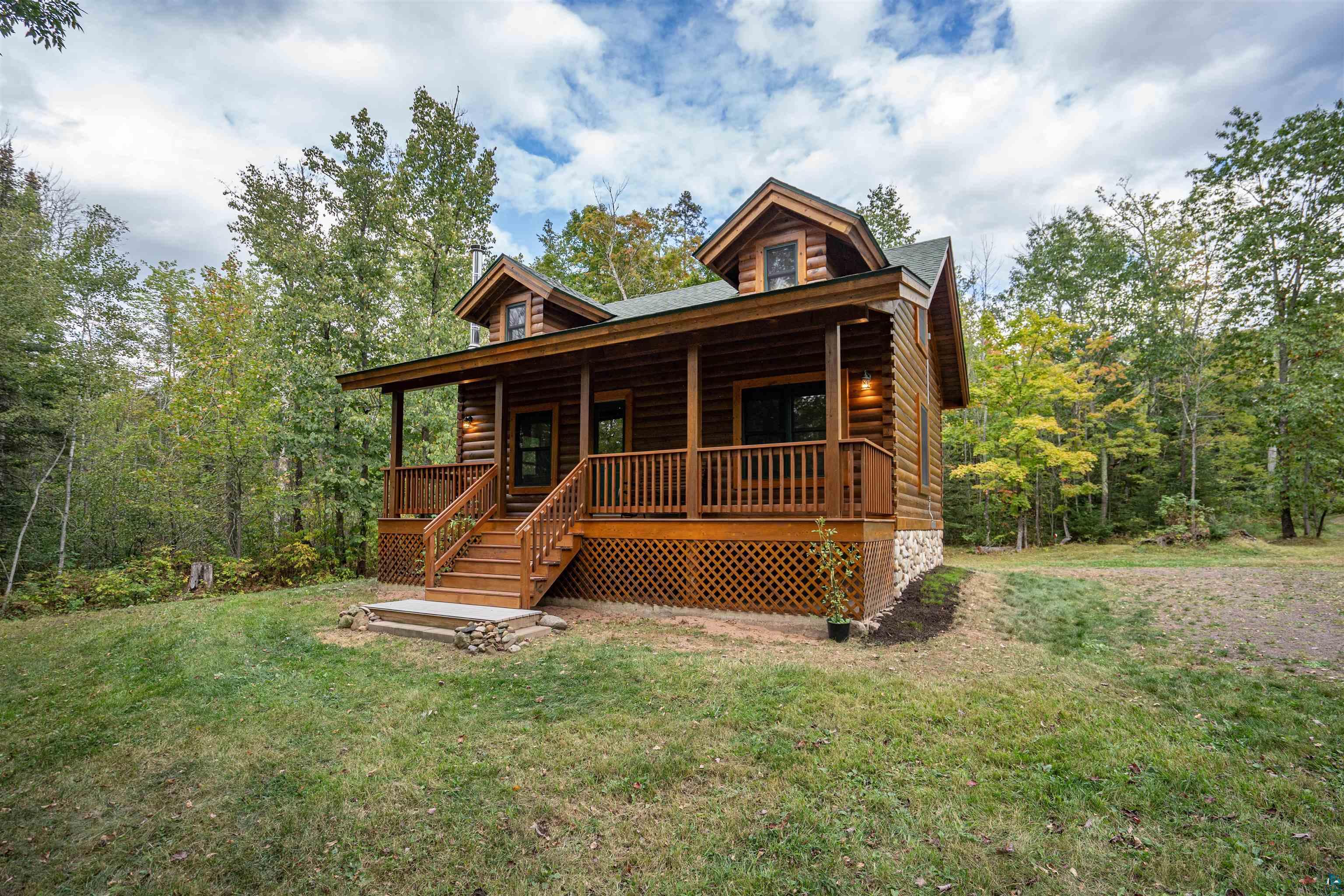 6711 South Jem Lane Lake Nebagamon, WI 54849 - Photo 1 of 28 Log cabin with a front lawn and covered porch