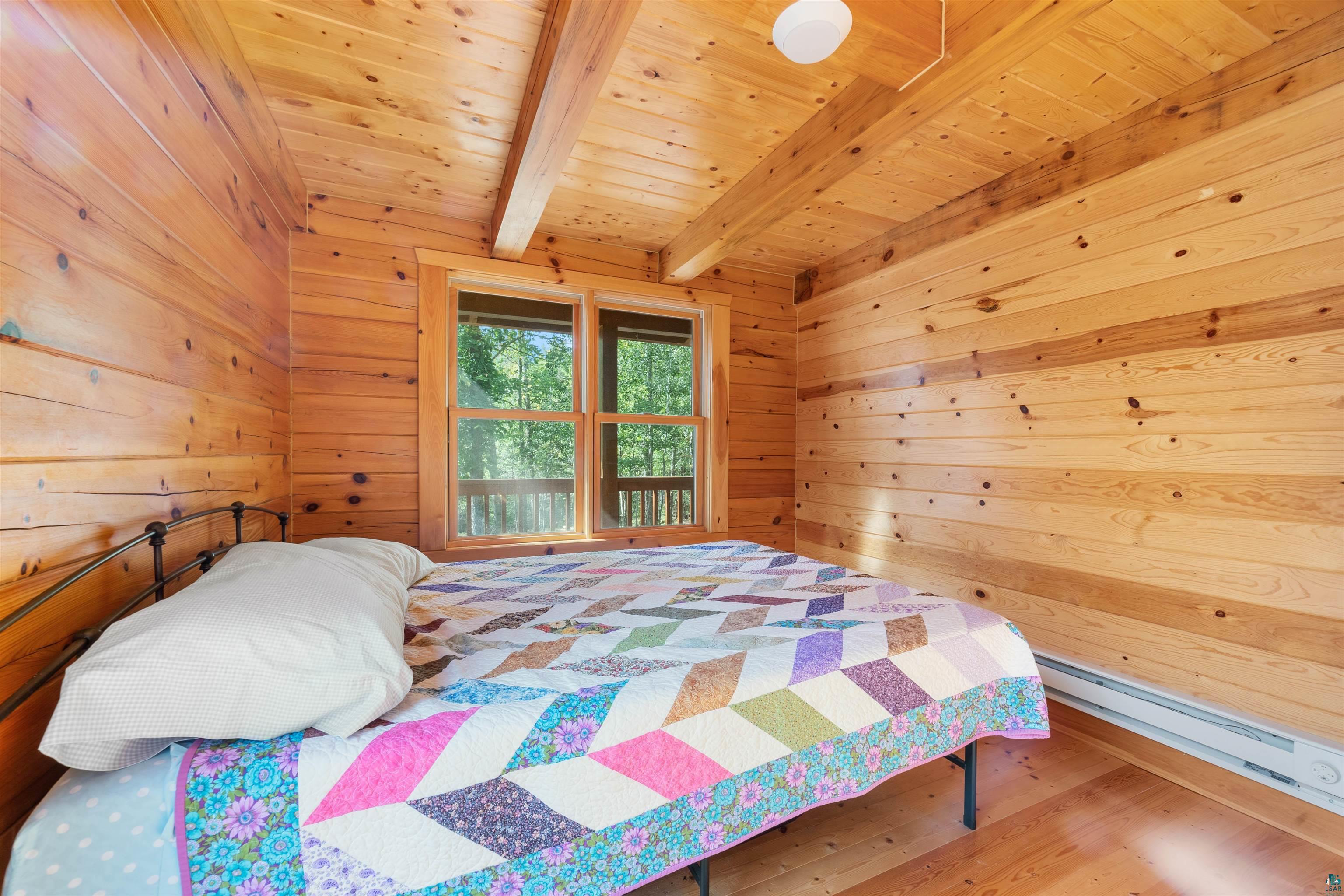 6711 South Jem Lane Lake Nebagamon, WI 54849 - Photo 12 of 28 Bedroom featuring hardwood / wood-style flooring, wooden walls, beam ceiling, and wood ceiling