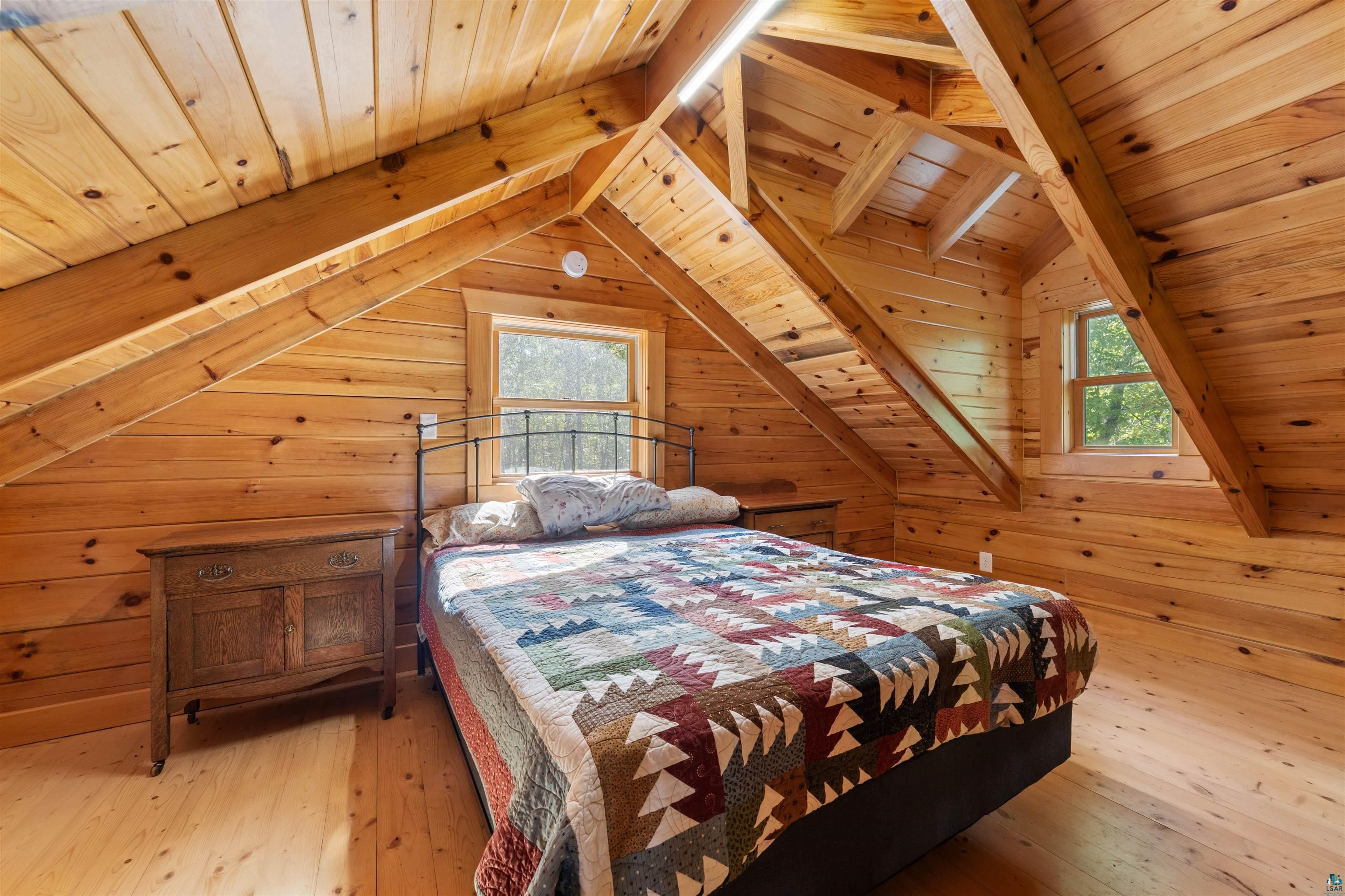 6711 South Jem Lane Lake Nebagamon, WI 54849 - Photo 14 of 28 Bedroom featuring light hardwood / wood-style flooring, wood walls, wood ceiling, and lofted ceiling with beams