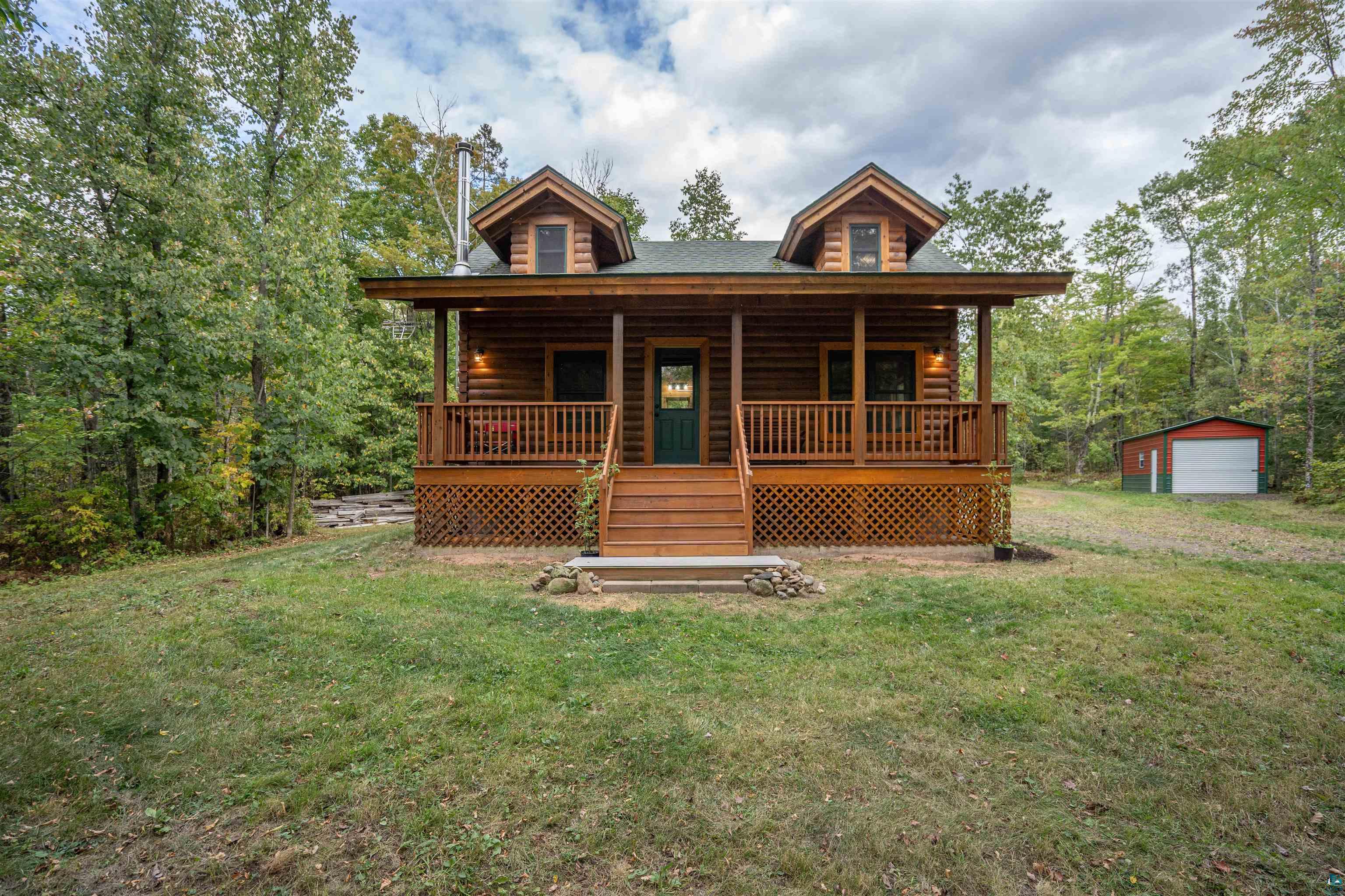 6711 South Jem Lane Lake Nebagamon, WI 54849 - Photo 16 of 28 Cabin with a front yard, an outdoor structure, a porch, and a garage