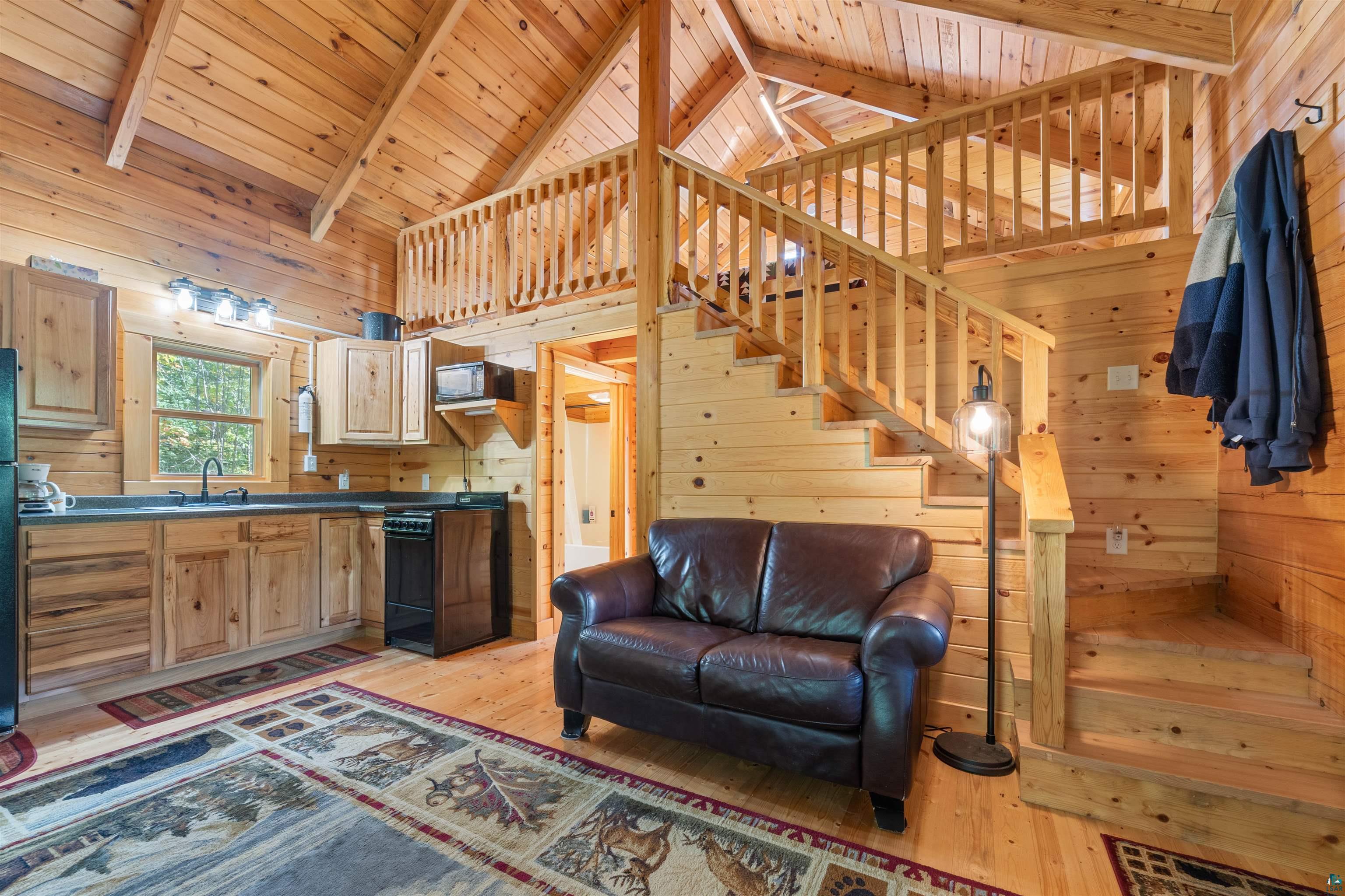6711 South Jem Lane Lake Nebagamon, WI 54849 - Photo 6 of 28 Living room with wooden walls, light wood-type flooring, and wooden ceiling