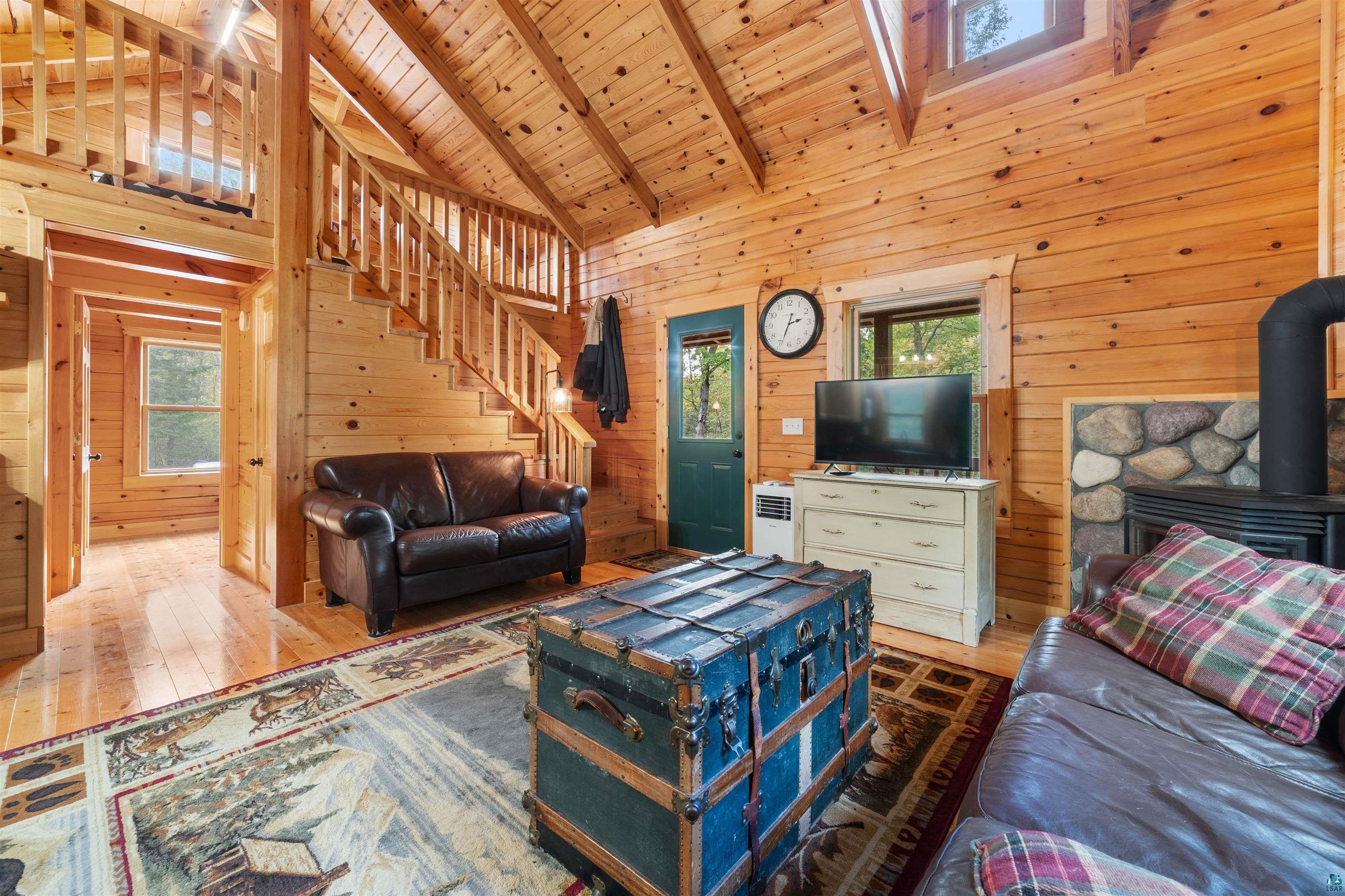 6711 South Jem Lane Lake Nebagamon, WI 54849 - Photo 7 of 28 Living room featuring wood ceiling, high vaulted ceiling, a wood stove, hardwood / wood-style flooring, and wooden walls