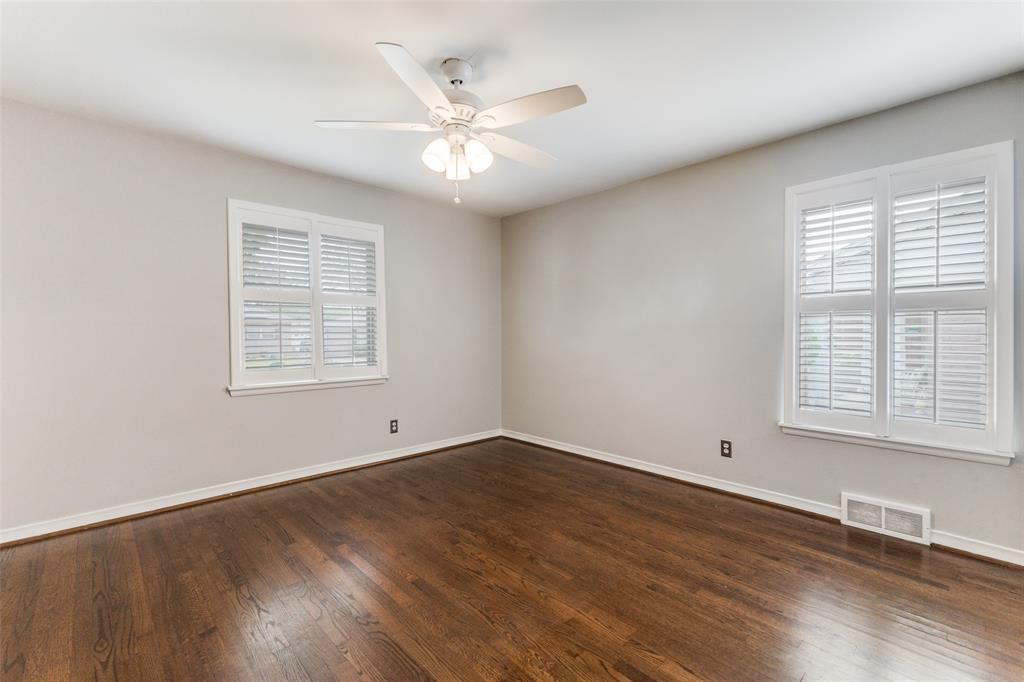 7128 Haverford Road Dallas, TX 75214 - Photo 13 of 24 an empty room with wooden floor chandelier fan and windows