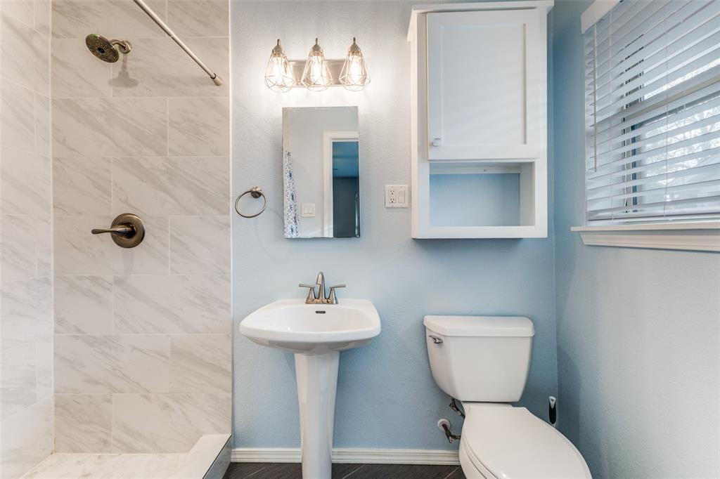7128 Haverford Road Dallas, TX 75214 - Photo 16 of 24 a bathroom with a toilet sink and mirror