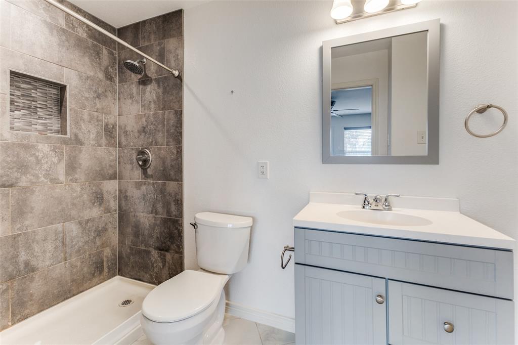 7128 Haverford Road Dallas, TX 75214 - Photo 24 of 24 a bathroom with a toilet a sink a mirror and shower