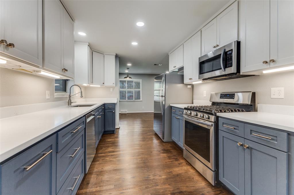 7128 Haverford Road Dallas, TX 75214 - Photo 8 of 24 a large kitchen with stainless steel appliances granite countertop a stove a sink dishwasher and a microwave oven with wooden cabinets