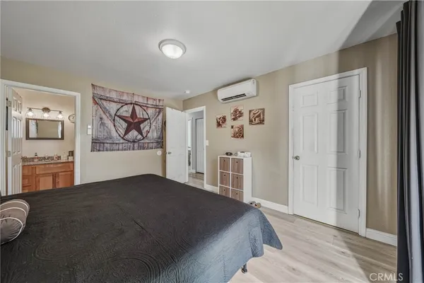a bedroom with a bed and painting on the wall