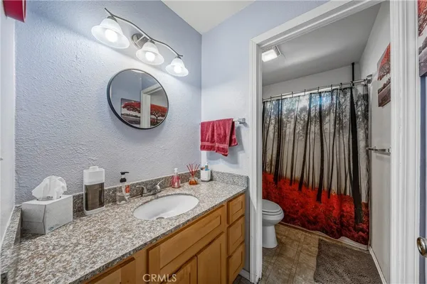 a bathroom with a granite countertop sink mirror vanity and toilet