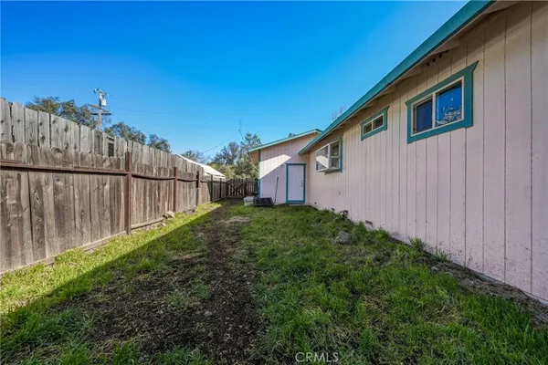 a view of a backyard with wooden fence