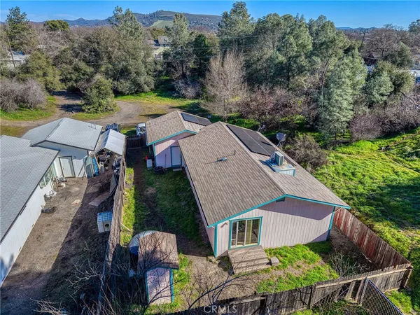 an aerial view of a house with swimming pool and mountains