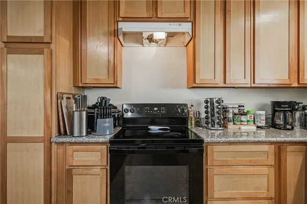 a kitchen with granite countertop stainless steel appliances a stove a refrigerator a sink and cabinets