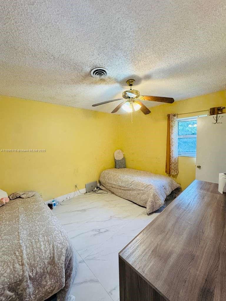 3405 Northwest 82nd Avenue Coral Springs, FL 33065 - Photo 11 of 26 a bedroom with a bed and a chandelier